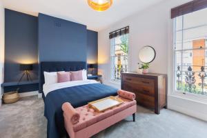 a bedroom with a bed and a chair and a mirror at Camden Home - Barracks Properties in London