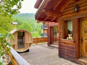 a wooden house with a bear sitting on a deck at 2AlpesChalets - Chalet Marie 2 - Standing et Sauna aux pieds des pistes in Les Deux Alpes