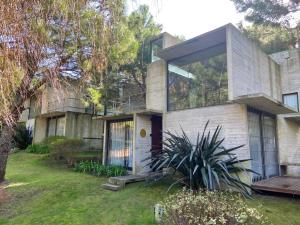 una casa con una gran ventana en el lateral en V & D - Casas en Mar Azul en Balneario Mar Azul