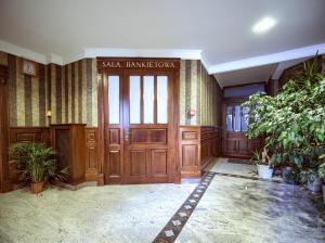 una hall con una grande porta in legno in un edificio di ApartHotel Hubertus a Białystok