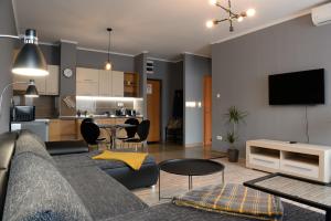 Macropolis Apartments في ميشكولتْس: غرفة معيشة مع أريكة ومطبخ