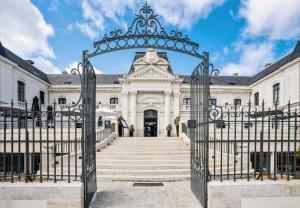 otwarta brama do białego budynku ze schodami w obiekcie Best Western Premier Hotel de la Cite Royale w mieście Loches