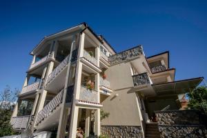 a large building with balconies on a blue sky at Apartmani Ana & Milo in Lopar