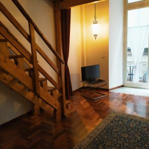 sala de estar con escalera y TV en Il Castello Apartment en Nápoles