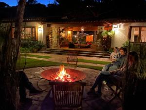 a group of people sitting around a fire pit at Villa Can Duarry - Barcelona Country House 1 in Premia de Dalt