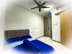 a bedroom with a blue bed with a ceiling fan at Harith sofea condo with pool in Kuala Terengganu +17 photos