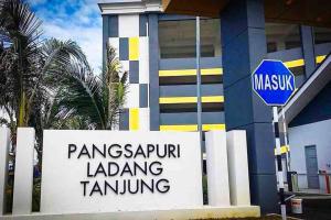 a sign in front of a building with a street sign at Harith sofea condo with pool in Kuala Terengganu