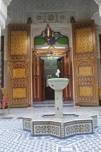a fountain in the middle of a room with a building at Riad Les Chrifis Navette Aéroport 24 sur 24 in Fez