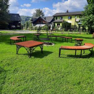 un grupo de mesas de picnic en un campo de hierba en Gościna U kowala, en Lachowice