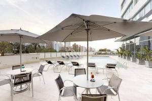 a patio with tables and chairs with umbrellas at Hermoso apartamento en la Arenosa in Barranquilla