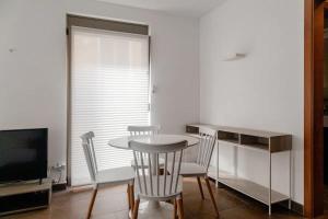een eetkamer met een tafel en stoelen en een televisie bij Residential Tourist Apartments in Caldes d'Estrac