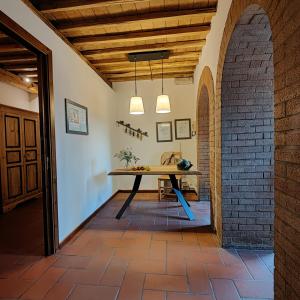 ein Esszimmer mit einem Tisch und einer Ziegelwand in der Unterkunft La Locanda Della Chiocciola in Orte
