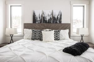 sypialnia z dużym białym łóżkiem z 2 lampami w obiekcie Spanish Peaks Highlands Cabin 45 w mieście Big Sky