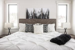 a bedroom with a large white bed with two lamps at Spanish Peaks - Highlands Cabin 45 in Big Sky