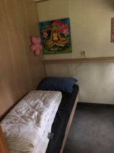een kleine kamer met een bed en een schilderij aan de muur bij Chalet 4-5 Pers in Epe F16 Van alle gemakken voorzien Max aantal volwassenen is 4 in Epe