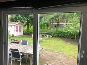 an open door to a patio with a table and chairs at Gezellig chalet voor gezinnen op de Veluwe I Veldkamp F16 in Epe