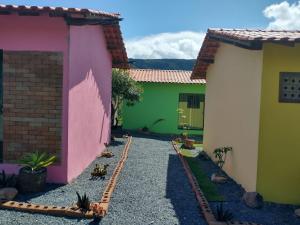a courtyard of two houses with a train track between them at Chalés Vila Bela Vale do Capão in Vale do Capao