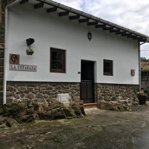 una casa bianca con un muro di pietra di LA COTARAXA a Piloña