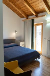 a bedroom with a blue bed and a window at IL Sogno in Montesano sulla Marcellana
