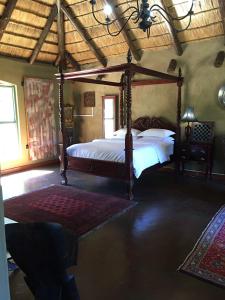 Un dormitorio con una cama con dosel en una habitación. en Ithaba Falls Guest Farm Farm L59, Buffelsvley, Burgersfort, 1150, en Boerboomskraal