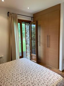 1 dormitorio con 1 cama grande y armarios de madera en GISCA, en Pauls de Flamisell