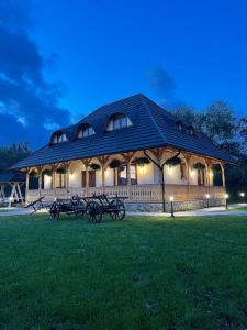 a large pavilion with a group of benches in the grass at Casa Moroșanului Vișeu de Sus in Vişeu de Sus