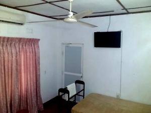 a room with a table and a television on the wall at Midland Hotel Rooms Kanampella in Kananpella