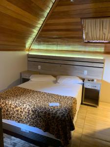 um quarto com uma cama e uma cabeceira em madeira em Pousada Schmitz em Canela