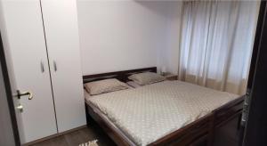 ein Schlafzimmer mit einem Bett und einem weißen Schrank in der Unterkunft Apartman ALTA in Vlasic