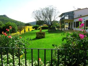 una casa con un patio con flores y una valla en Casa Rural La Sierra de Monfragüe, en Malpartida de Plasencia