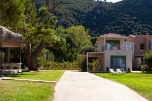 a house with a lawn and a sidewalk at Brunello Seaside Apartments in Lefkada Town