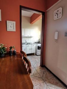 a dining room with a table and a kitchen at Apart da Cachoeira in Florianópolis