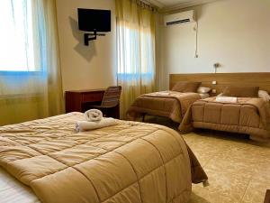 a hotel room with two beds and a tv at Hostal Torresmancha in La Guardia