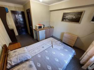 niewielka sypialnia z łóżkiem i kuchenką mikrofalową w obiekcie Отель Юность w Kijowie