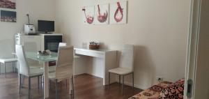 a dining room with a table and chairs and a kitchen at Le Lune di Diana in Matera