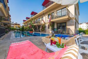 a house with a swimming pool in front of a building at Yaşam Park Residence - Fethiye Calis Beach in Fethiye