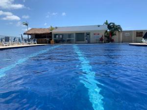 einem Pool mit blauem Wasser vor einem Gebäude in der Unterkunft Golden Lake in Arraial do Cabo
