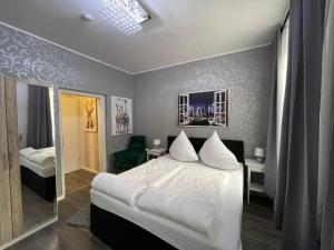 um quarto com uma cama branca e um espelho em Boutiquehotel Mason em Altemburgo