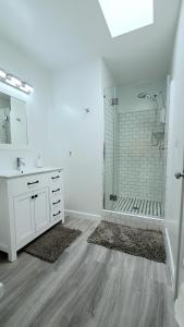 baño blanco con ducha y lavamanos en Double Suite Santa Monica - Free Parking, en Santa Monica