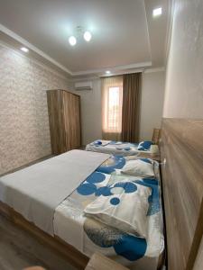 a bedroom with two beds with blue and white sheets at Onestep in Kutaisi