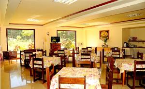 a dining room with tables and chairs and a television at Hotel Presidente Selva in La Merced