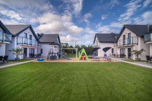 a large yard with a playground in a house at Domki Cała Naprzód in Jastrzębia Góra
