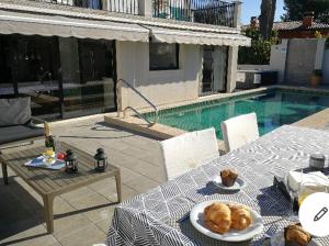 einen Tisch mit Teller mit Speisen neben einem Pool in der Unterkunft Luna Bay Palma in Palma de Mallorca