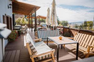 Un patio con sillas, mesa y sombrilla. en Hotel Relax Sovata, en Sovata