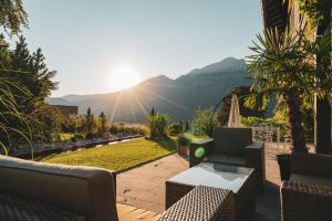 a patio with furniture and a view of a mountain at Villa Sonnenhof Boutique-Hotel in Bad Reichenhall