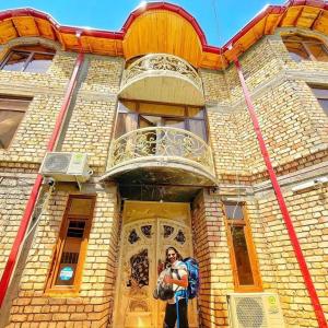 un hombre está parado frente a un edificio en Samarkand Сity Guest House en Samarcanda