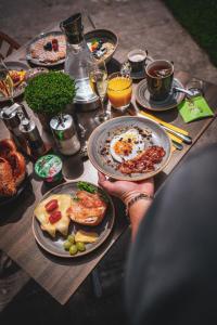 a person holding a plate of food on a table at Villa Sonnenhof Boutique-Hotel in Bad Reichenhall