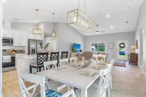 a dining room and kitchen with a white table and chairs at BRAND NEW Rental with Luxury Pool - Villa Rosalie - Roelens Vacations in Englewood