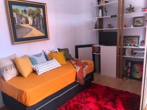 sala de estar con sofá naranja y almohadas coloridas en Pocitos Nuevo, en Montevideo