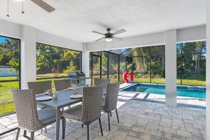 a dining room with a table and chairs and a pool at BRAND NEW Rental with Luxury Pool - Villa Rosalie - Roelens Vacations in Englewood